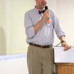 The speaker shares on the podium photo 1.