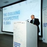 The speaker shares on the podium photo 8.