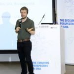 The speaker shares on the podium photo 18.